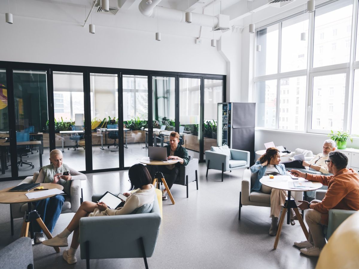 Customers searching on their phones and laptops in a bright lounge
